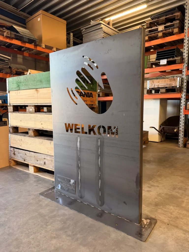 Welkomstbord in cortenstaal met uitgesneden zwaaiende hand.